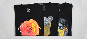 Three folded printed T-shirts. On the left is a bright orange and yellow rose in a white rounded square. In the middle a blue eyed lioness with a gold chain face mask. On the right a black and white lion with yellow eyes and a yellow warrior face mask.